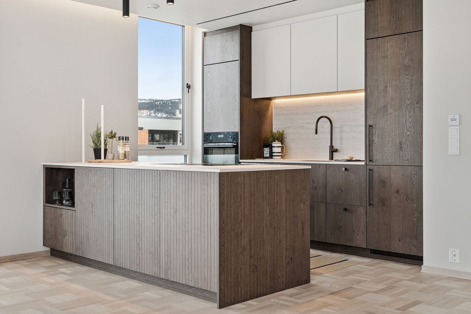 Lekkert kjøkken med dekton benkeplate og integrerte hvitevarer. Galleribilde