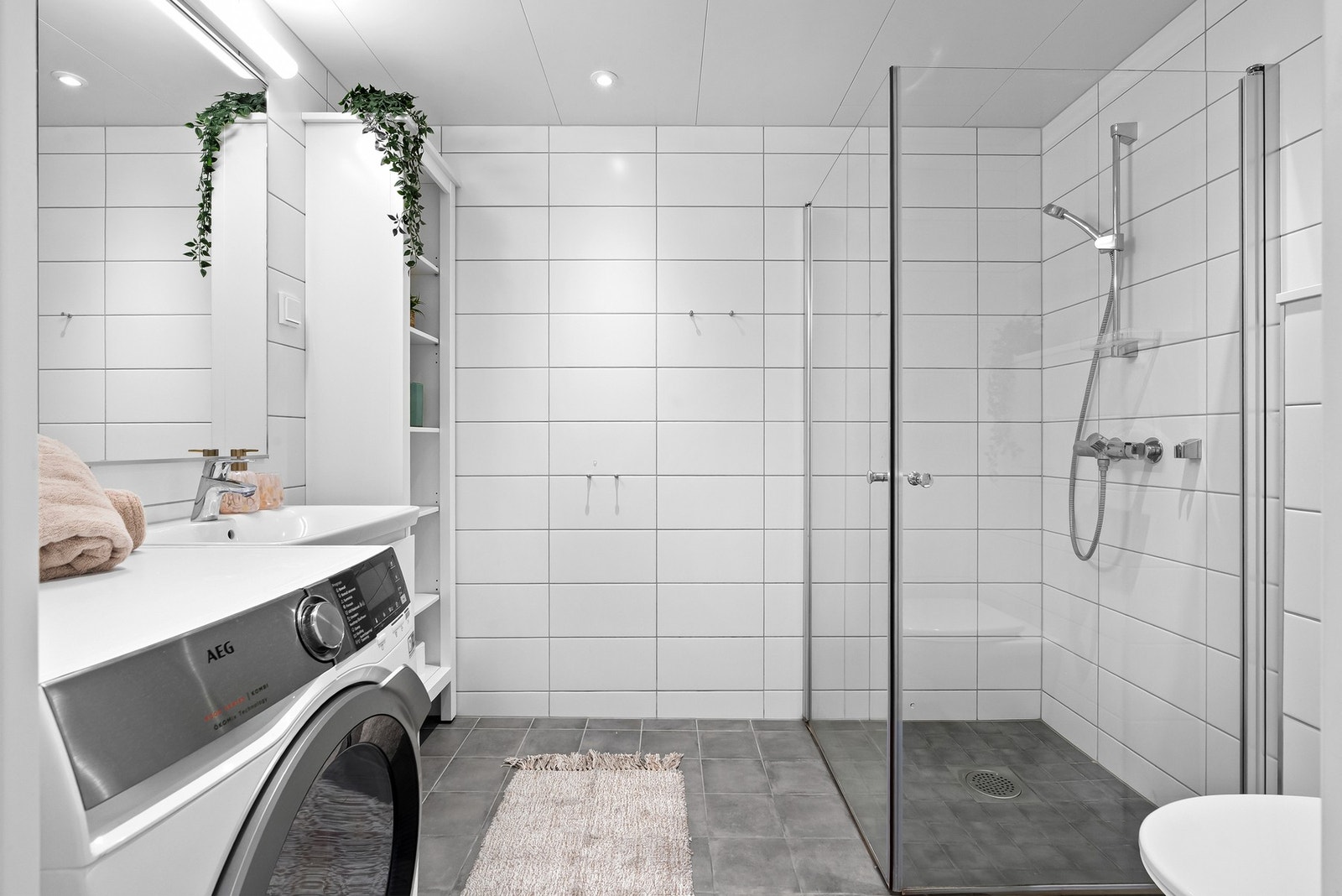 Stilrent bad fra 2021 med downlights, gulvvarme og opplegg for både vaskemaskin og tørketrommel. Galleribilde