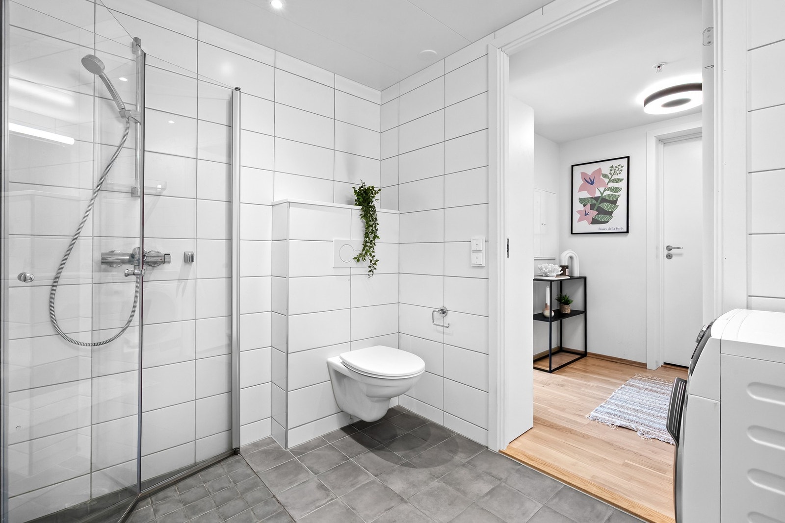 Vegghengt wc og innebygd sisterne med pyntekant over samt nedsenket dusjsone med sluk i sone Galleribilde