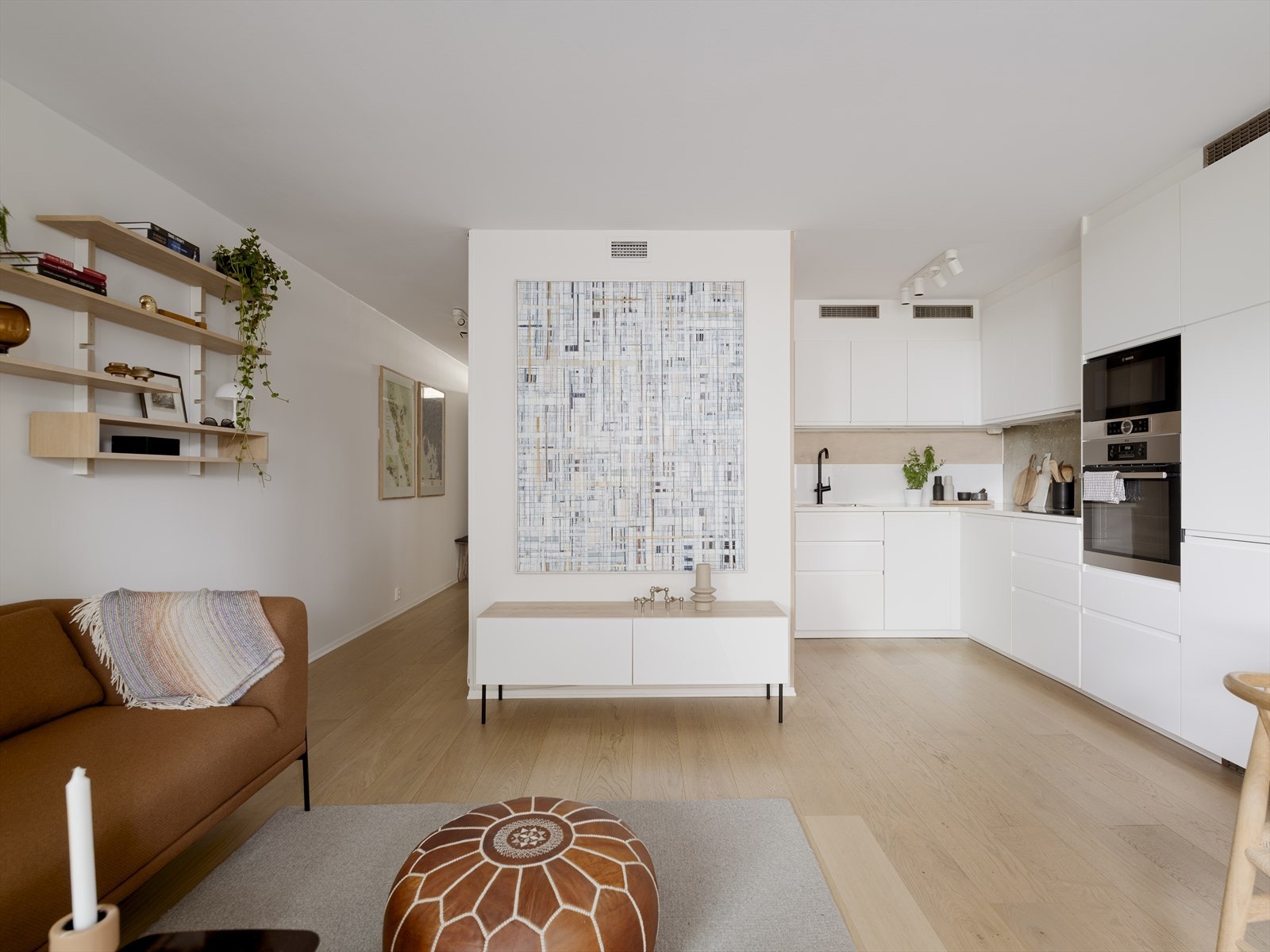 Lys og innbydende stue i åpen løsning mot kjøkkenet gir leiligheten en luftig og sosial atmosfære Galleribilde