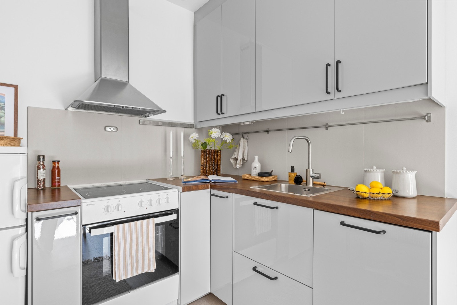 Kjøkken med hvit innredning og laminat benkeplate Galleribilde