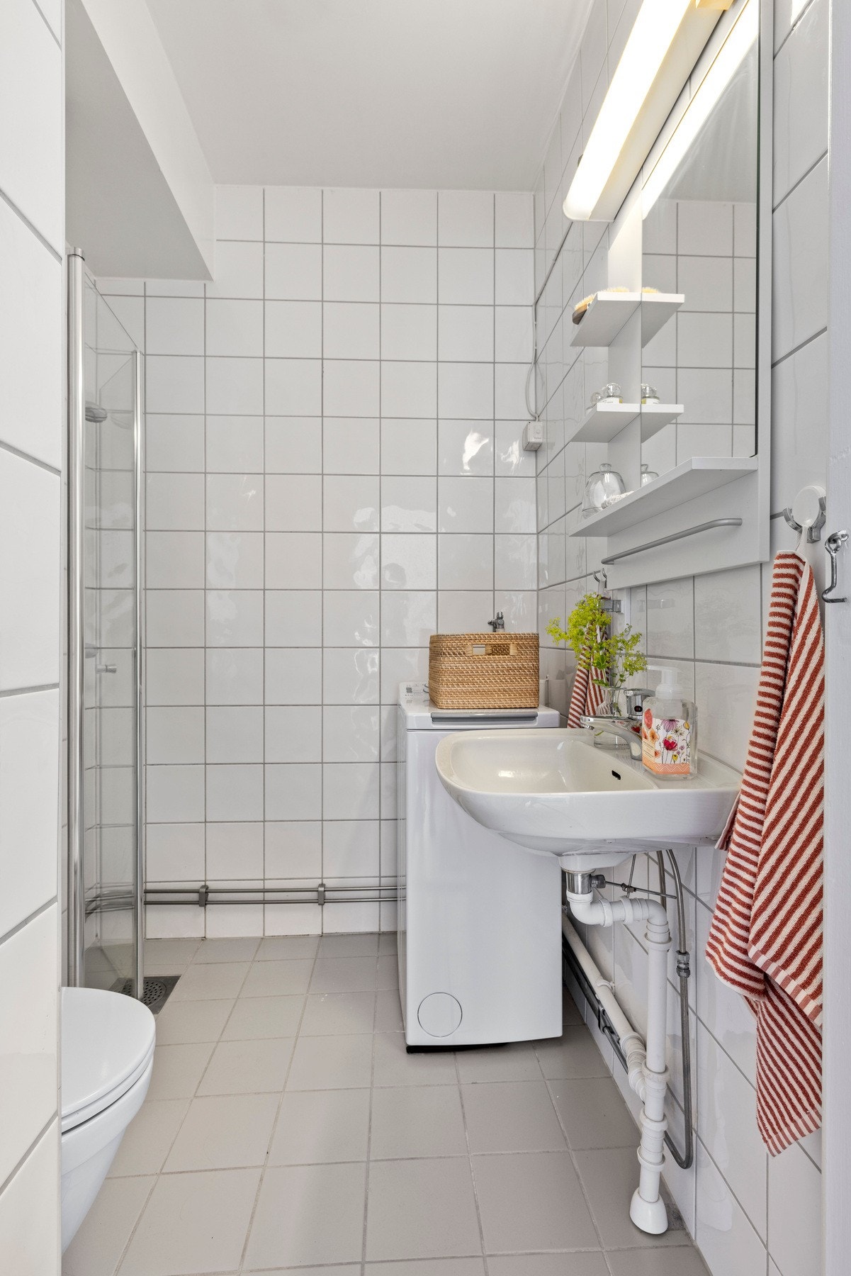 Flislagt bad med gulvvarme og opplegg for vaskemaskin. Galleribilde