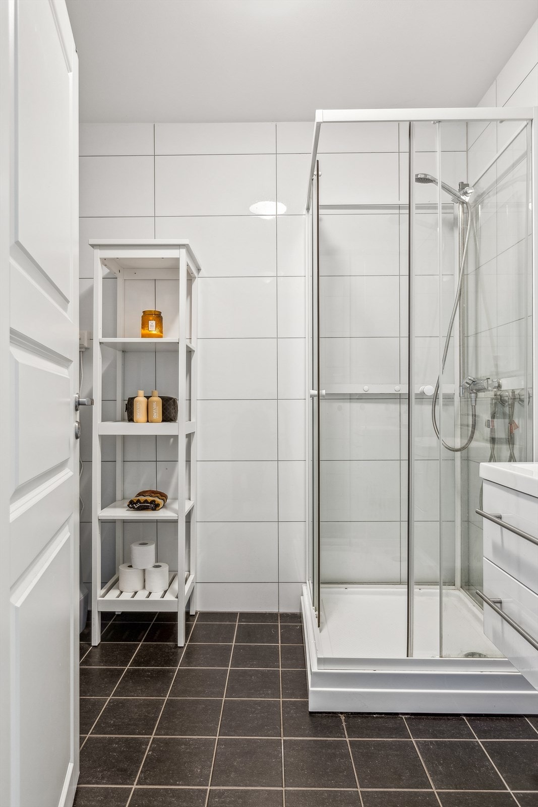 Badet er flislagt på gulv og vegg, med malt slett himling i tak. Galleribilde