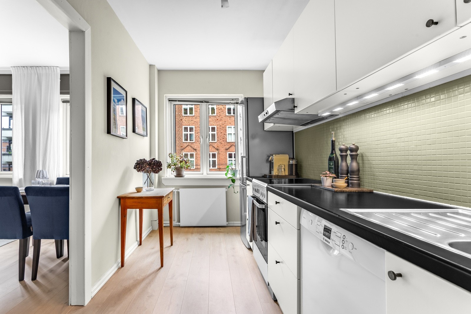 Lekkert kjøkken med lys og tidløs kjøkkeninnredning. Innredningen har glatte fronter og laminert benkeplate. Galleribilde