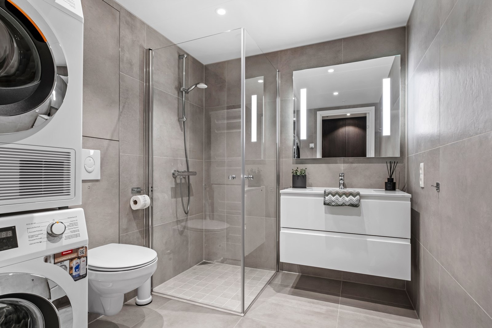 Badet er innredet med pene 60x60 fliser på gulv og vegger og downlights med dimmefunksjon. Galleribilde