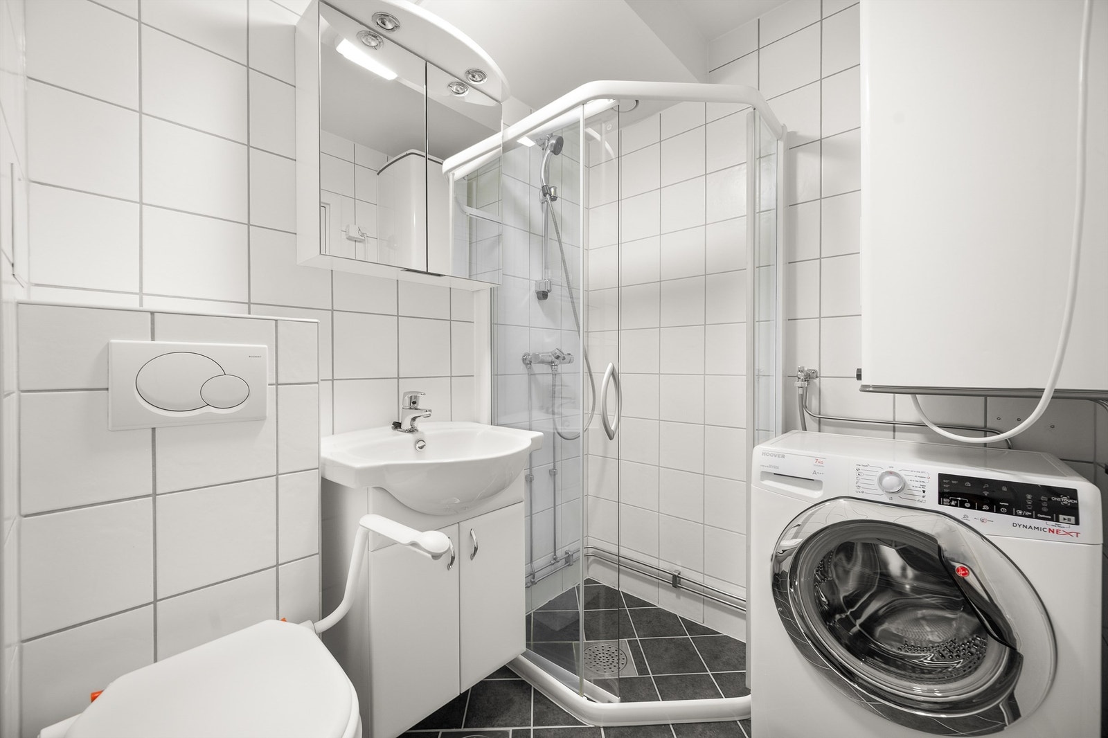 Dusjhjørne med svingbare glassdører. Opplegg for vaskemaskin. Galleribilde