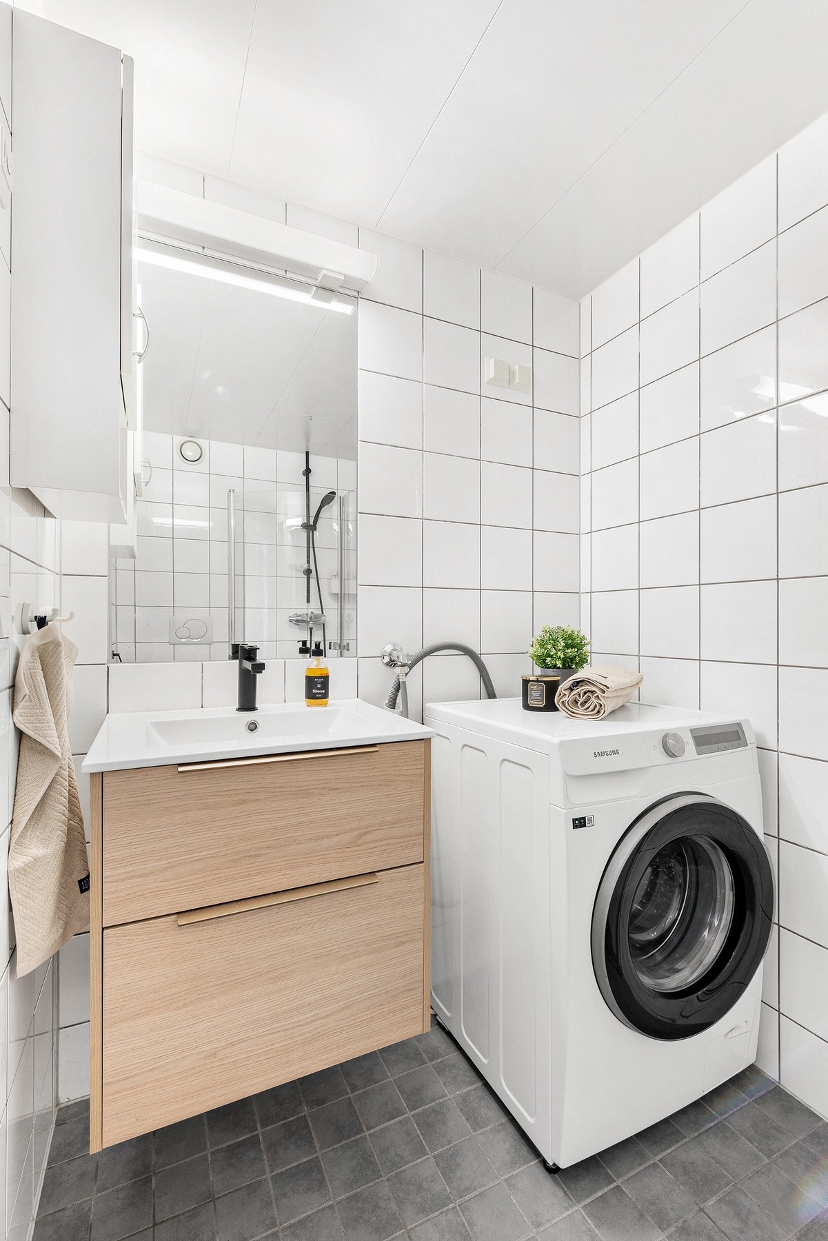 Badet er levert som en prefabrikkert baderomskabin i stål. Rommet har flislagte vegger som gir et rent og moderne uttrykk, og himlingen er kledd med aluminiumsplater Galleribilde