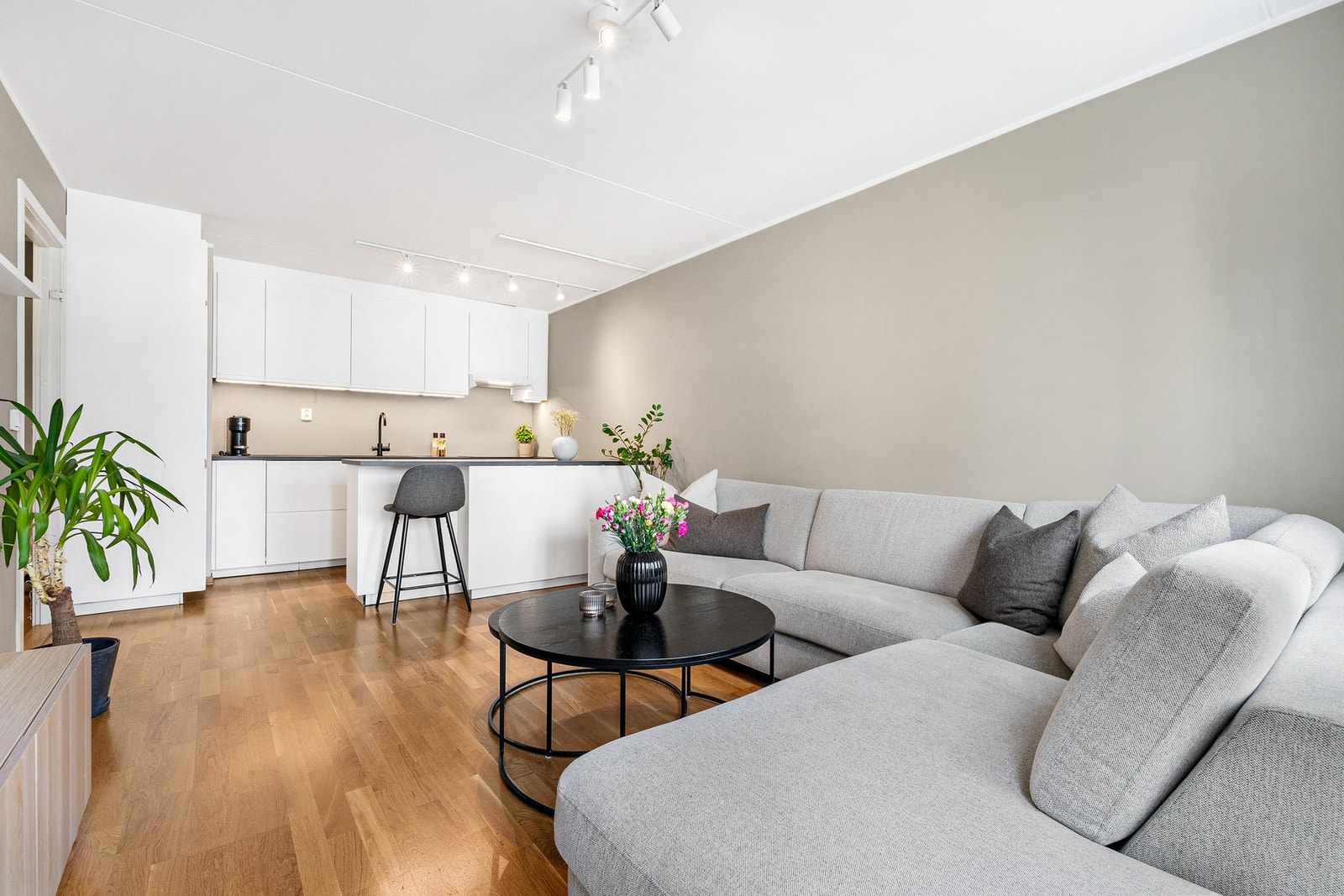 Som hjemmets sentrale rom fungerer den åpne stue-kjøkken løsningen som en arena for både hvile og samhandling - et sted der tilstedeværelse og fellesskap får en naturlig plass. Galleribilde