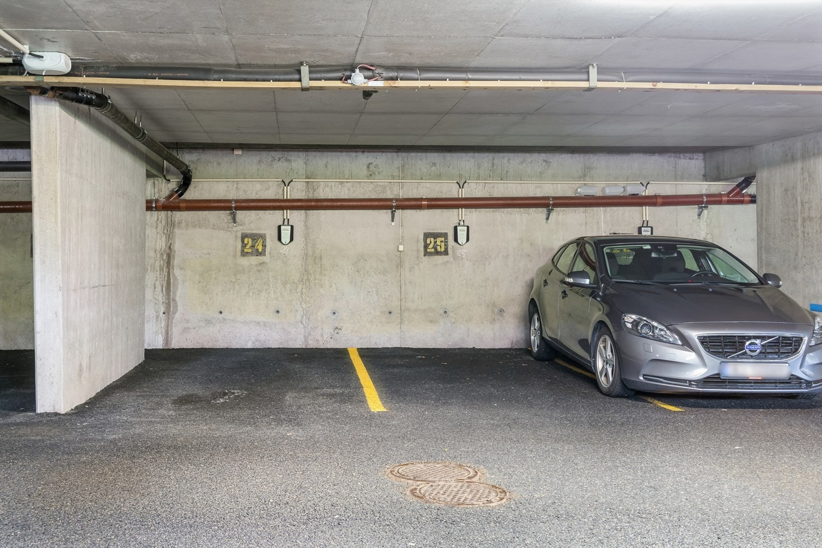 Parkeringsplass i lukket garasjeanlegg. Opplegg for lading på plassen. Galleribilde