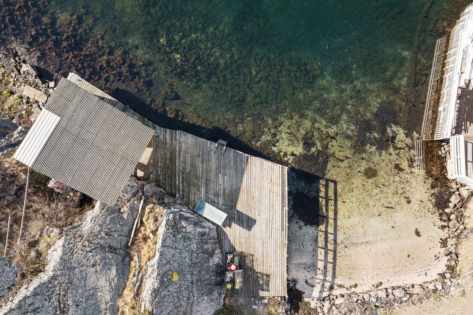 Attraktiv strandlinje med sandstrand og brygge. Galleribilde