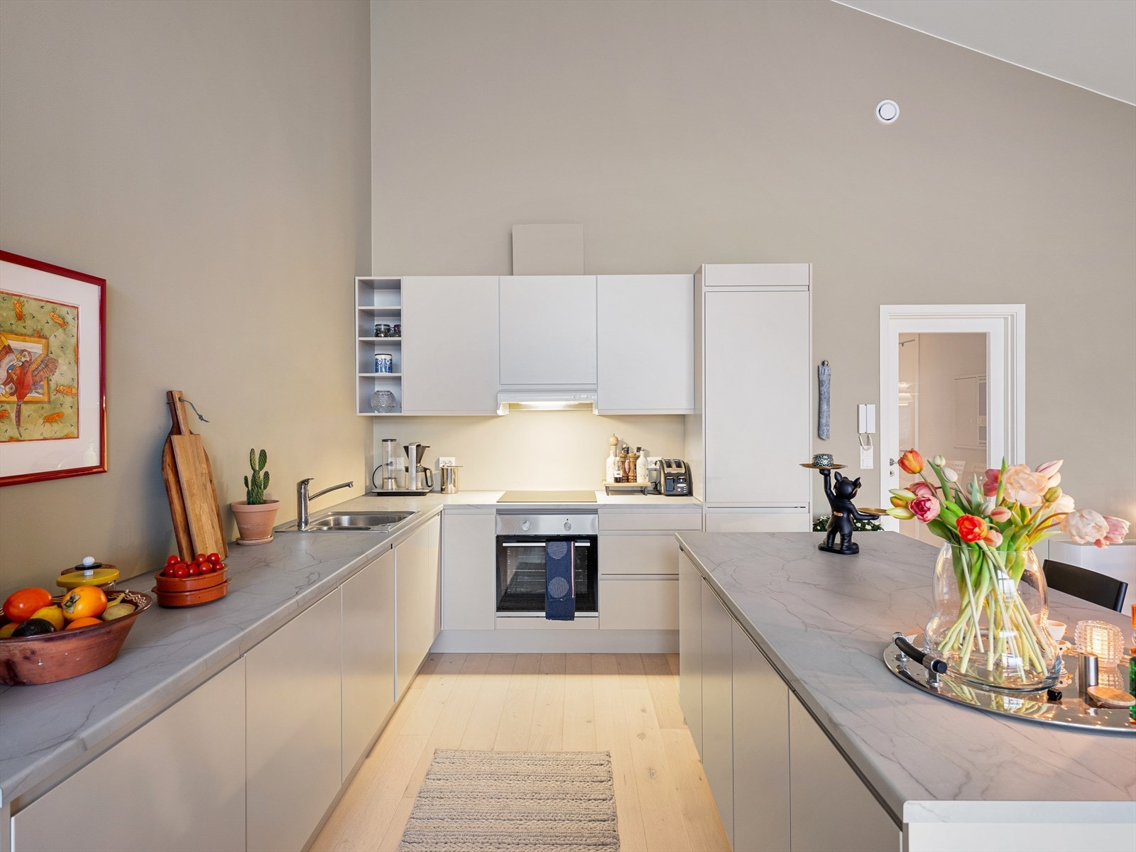 Kjøkkenet er stilrent og meget funksjonelt. Innredningen har glatte fronter og marmormønstret benkeplate i laminert spon. Galleribilde