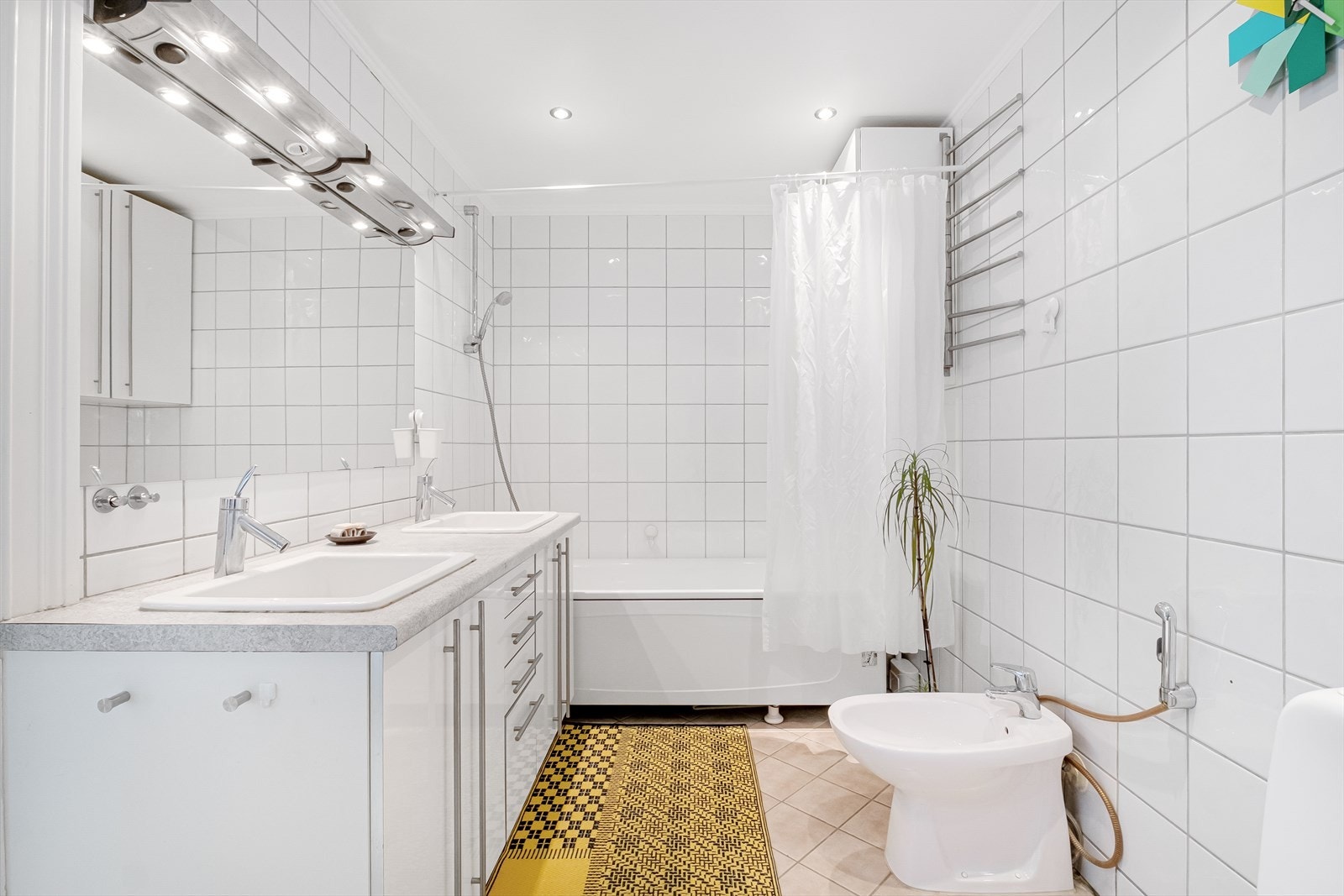 Pent flislagt bad med downlights i taket og badekar. Galleribilde