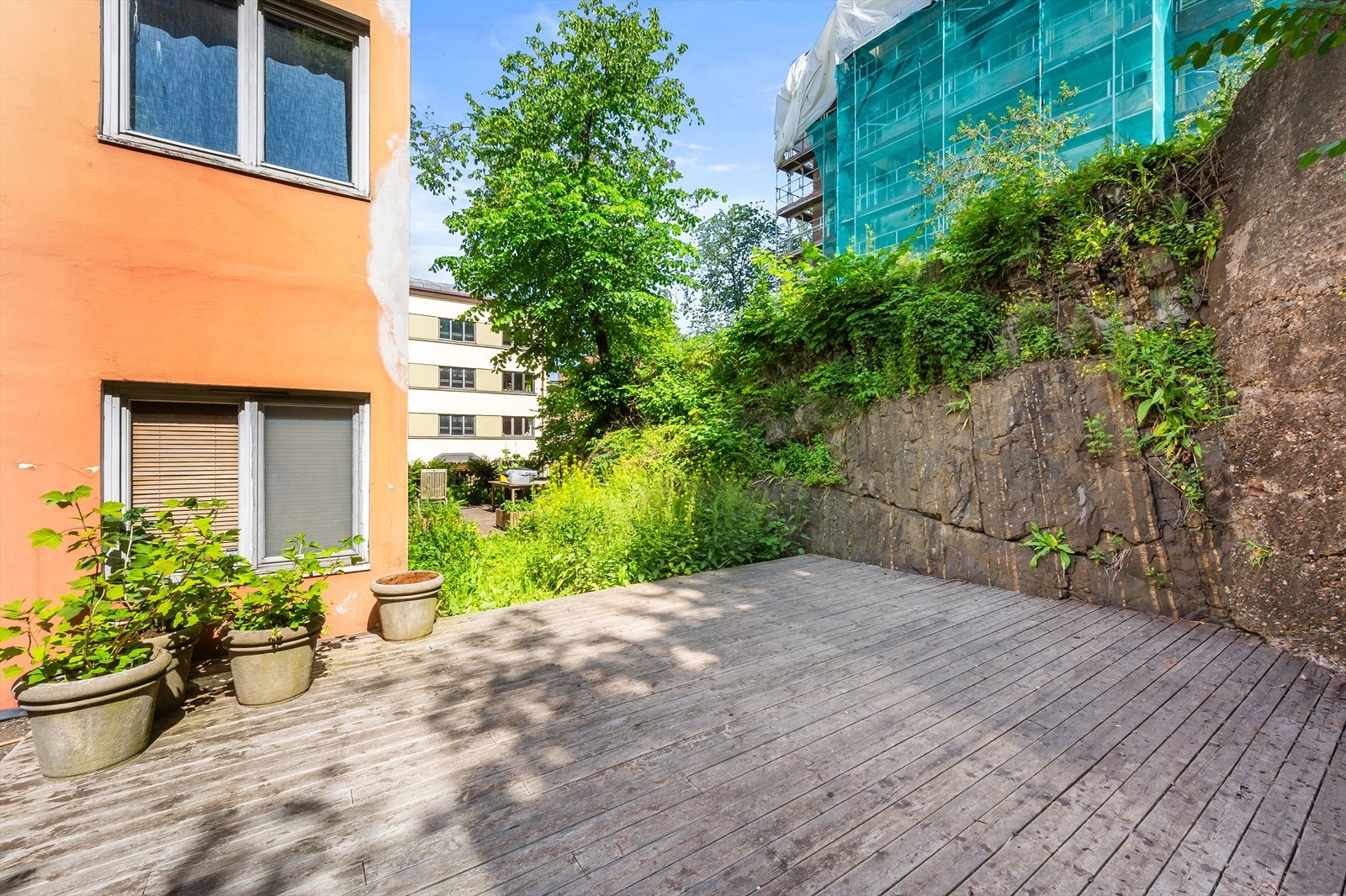 Hyggelig og pent opparbeidet bakgård med stor platting. Galleribilde