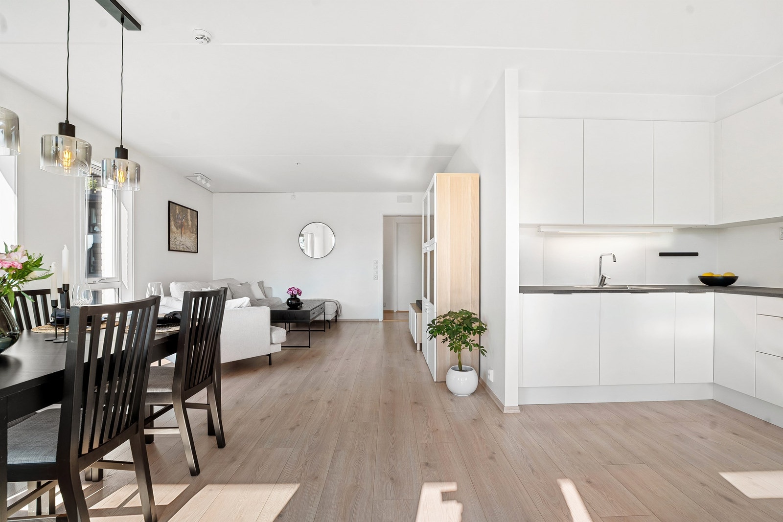 Den åpne løsningen mellom stuen og kjøkkenet gir leiligheten et sosialt preg. Galleribilde