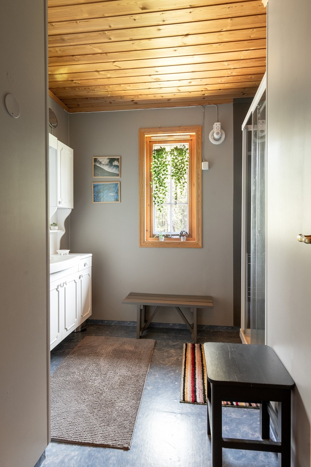 Badet er innredet med dusjkabinett og baderomsinnredning med underskap, overskap, speil og overlys med el-stikk. Galleribilde