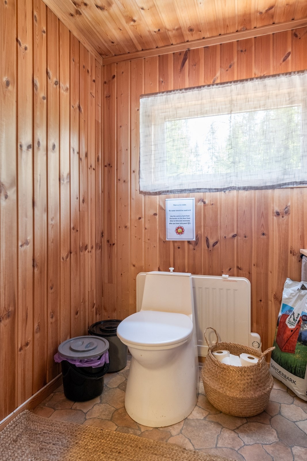 Enkelt toalettrom med snurredo og vaskevannsfat for håndhygiene. Galleribilde