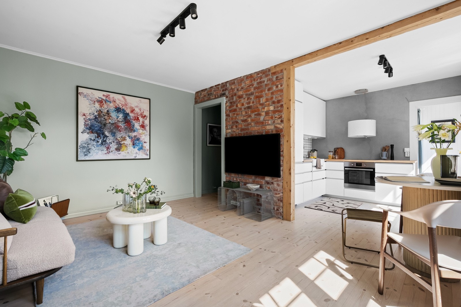 Stuen ligger i åpen løsning mot kjøkkenet, noe som skaper et hyggelig og sosialt oppholdsrom. Galleribilde