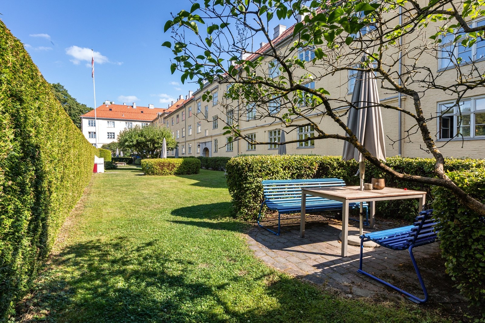 Bakgården er velholdt med flere sittegrupper og beplantning. Galleribilde