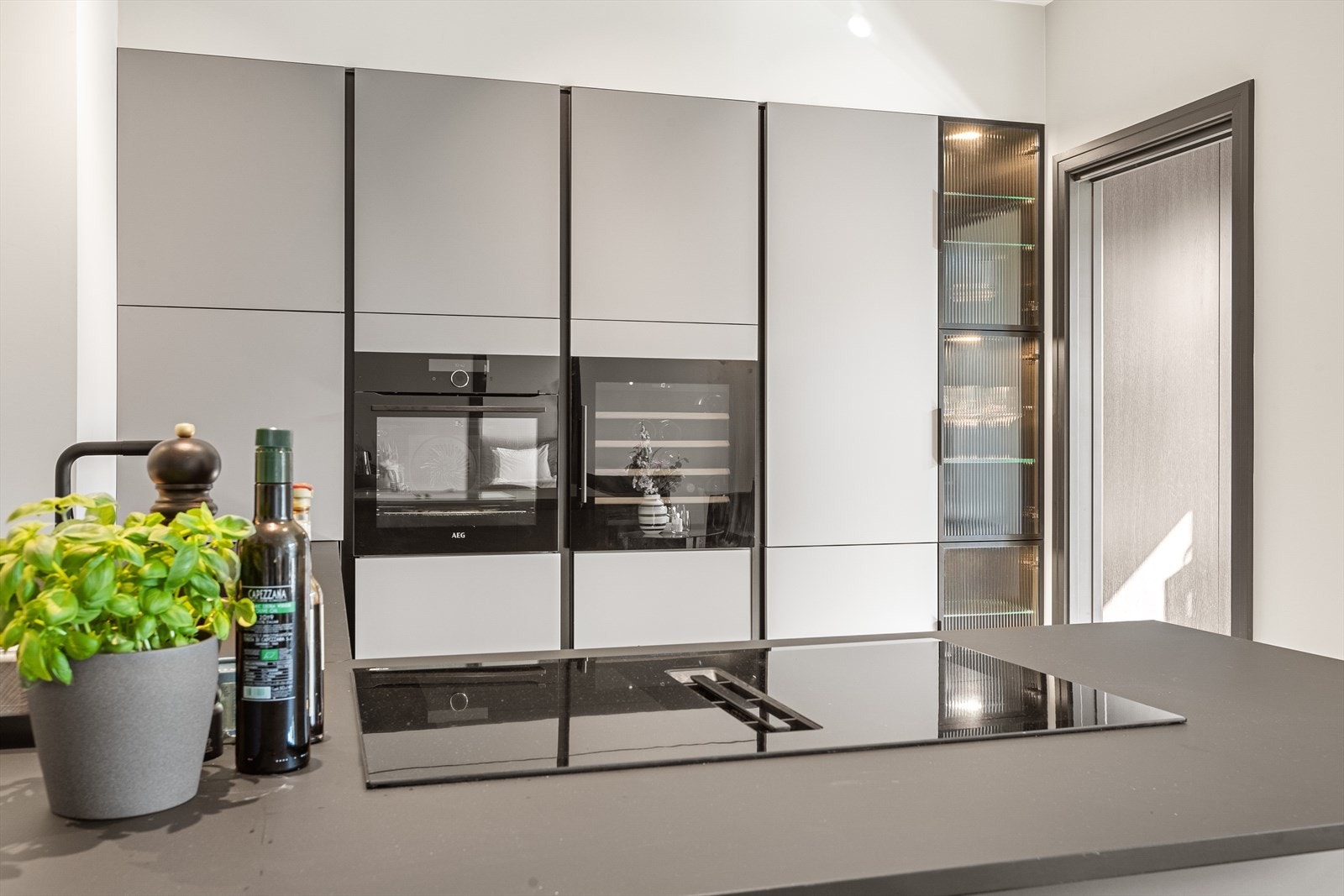 Moderne kjøkken med imponerende mye skap- og benkeplass. Galleribilde