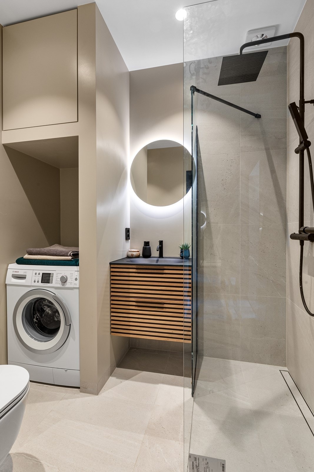 Delikat flislagt baderom pusset opp i 2022 med stilrene fliser, solid innredning, downlights og gulvvarme. Galleribilde