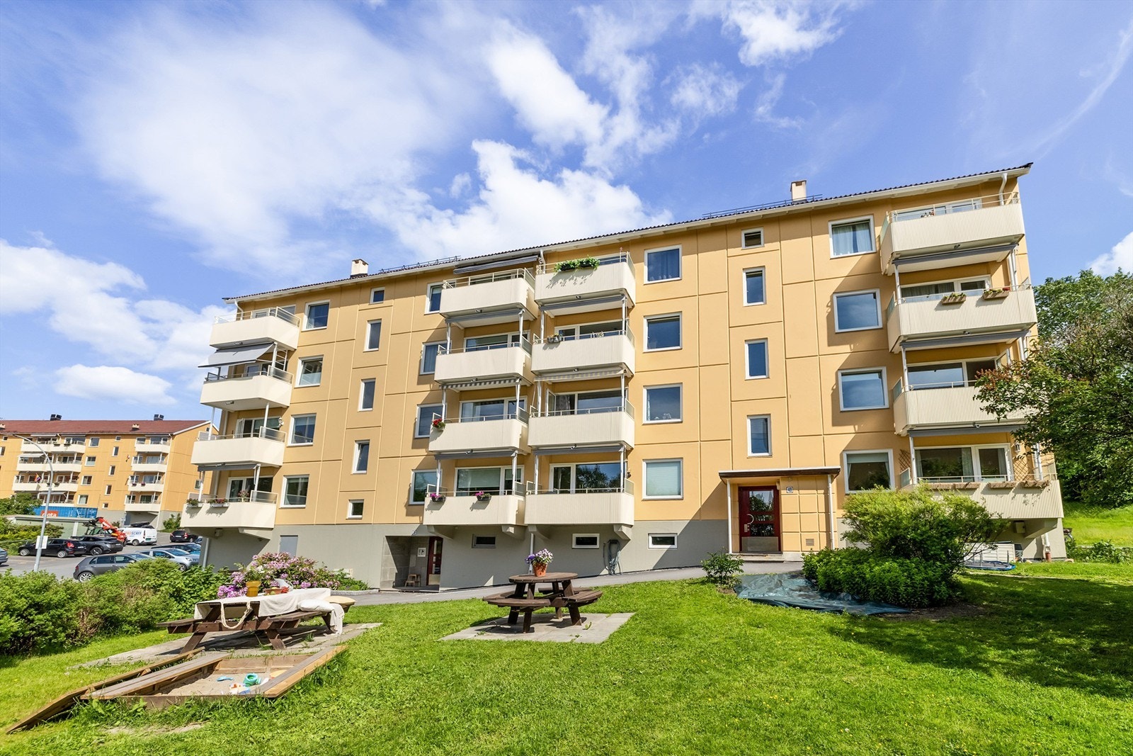 På forsiden av blokken er det satt ut sittegruppe som innbyr til grilling, mens barna sparkesykler eller hopper paradis Galleribilde