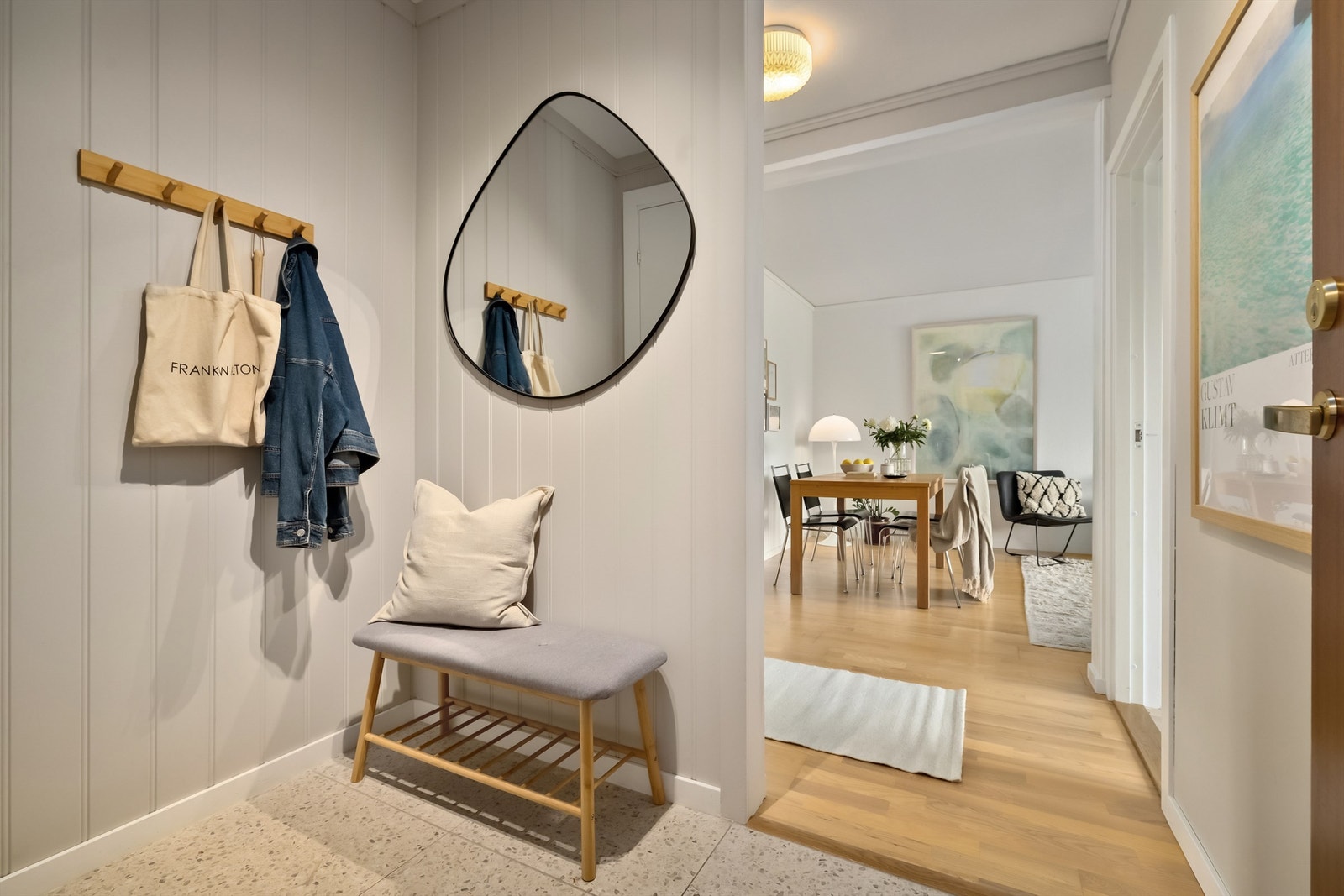 Veggflatene i entreen er malt i fargen "kalk" og på gulvet er det moderne fliser som komplementerer veggfargen Galleribilde