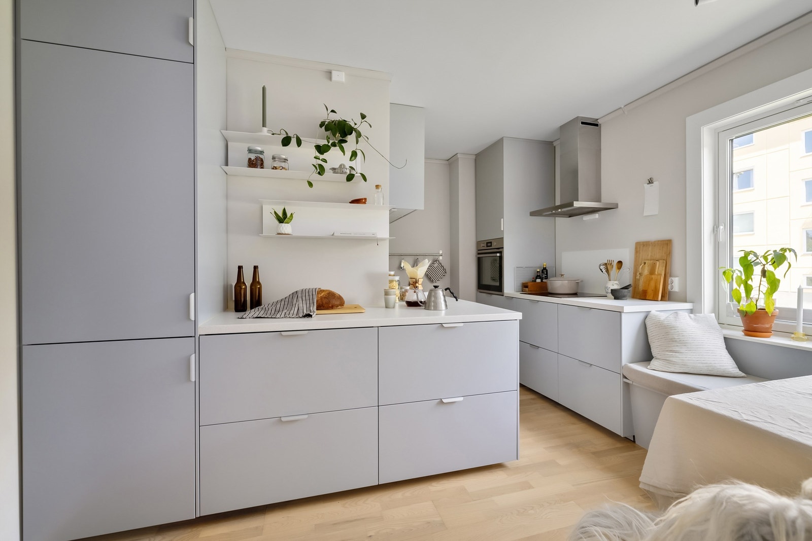 Kjøkkeninnredning med lyse, glatte fronter, benkeplate i laminat og oppvaskkum med ett-greps armatur Galleribilde