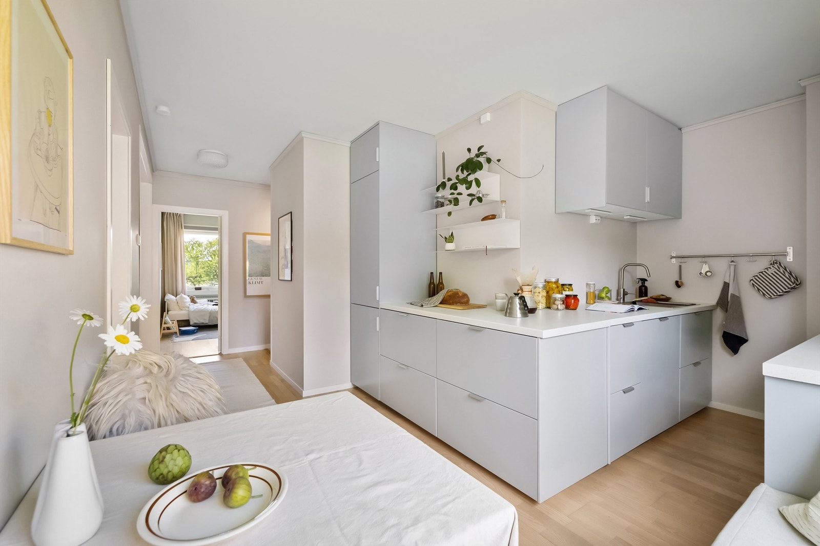 Integrerte hvitevarer som stekeovn, nedfelt koketopp med kullfilterventilator over, oppvaskmaskin og kjøleskap med frysedel Galleribilde