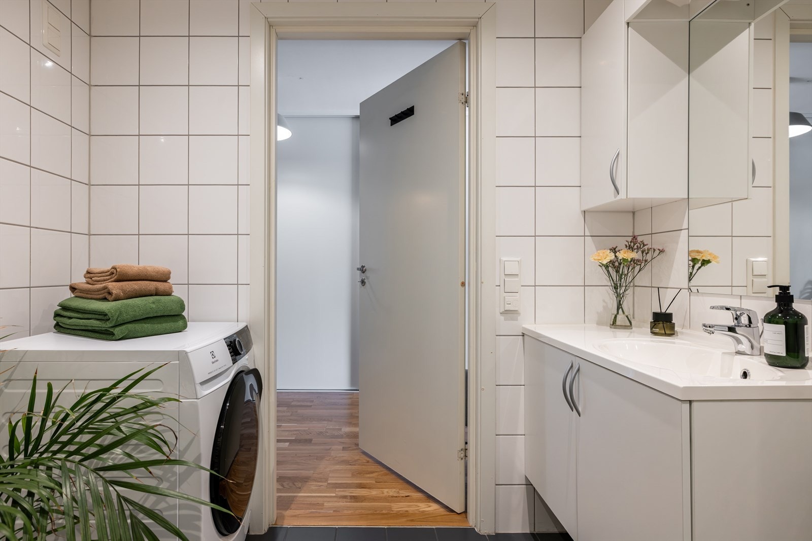 Rommet er innredet med moderne servant på underskap, speil med overlys og vegghengt toalett. Praktisk dusjhjørne med innfellbare, plassbesparende glassdører. Galleribilde