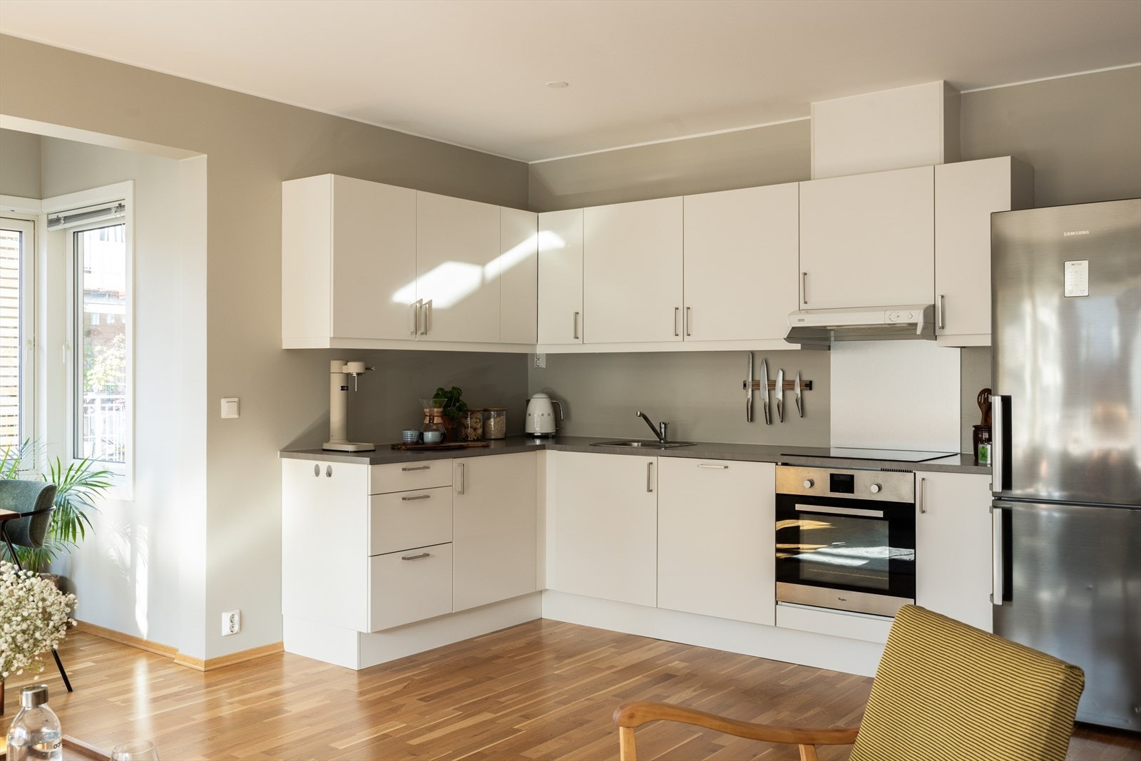 Kjøkkeninnredning med moderne, glatte fronter og laminat benkeplate med nedfelt vaskekum. Praktisk belysning over benk gir godt arbeidslys. Galleribilde