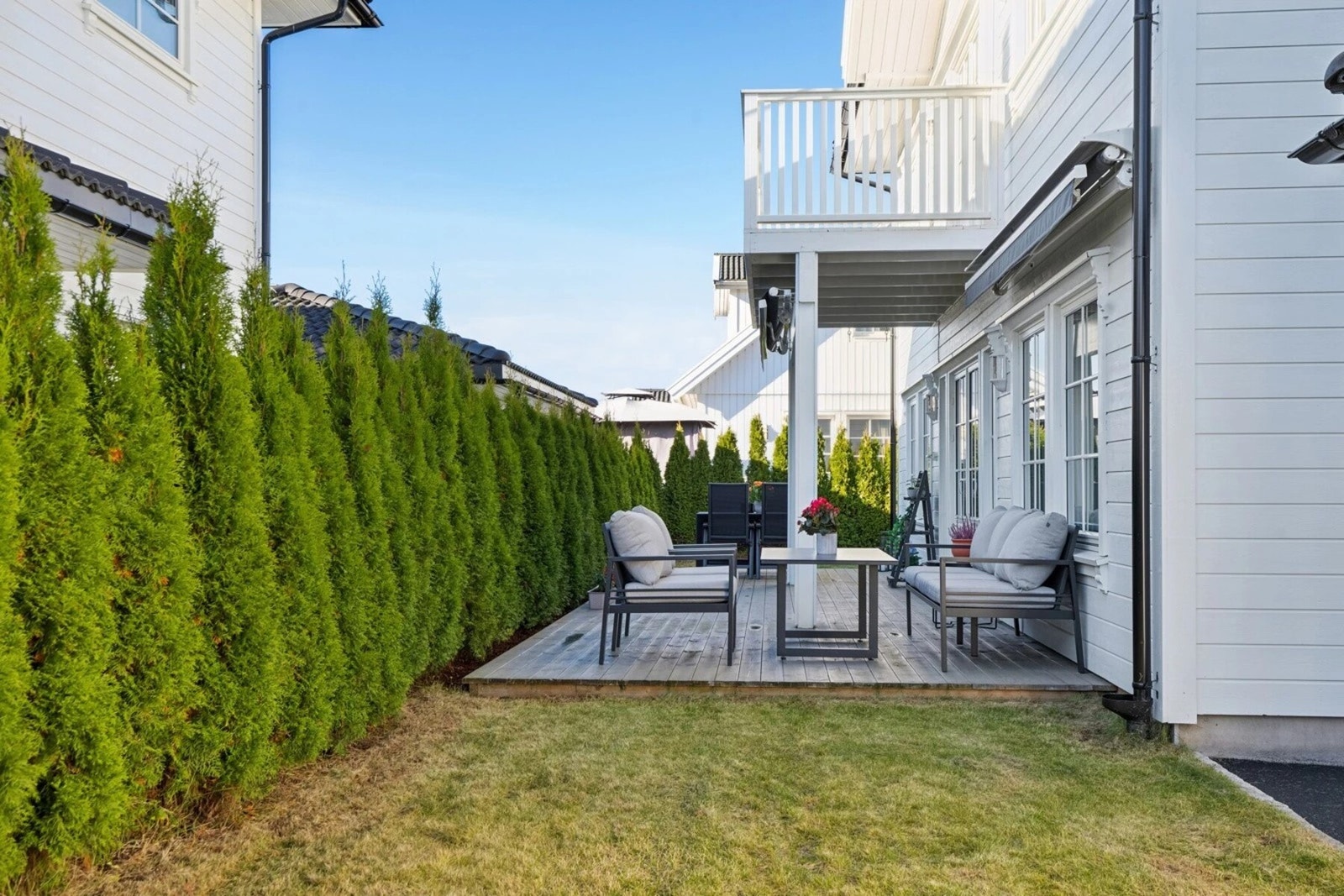 Terrassen blir skjermet av en praktisk tuiahekk. Galleribilde