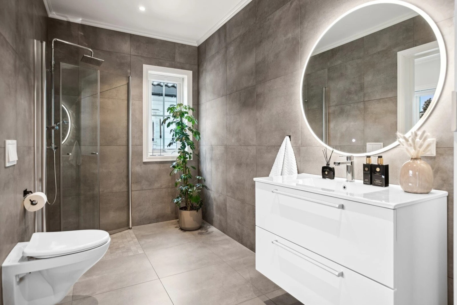 Baderommet er utstyrt med hjørnedusj, vegghengt servant og toalett. Galleribilde