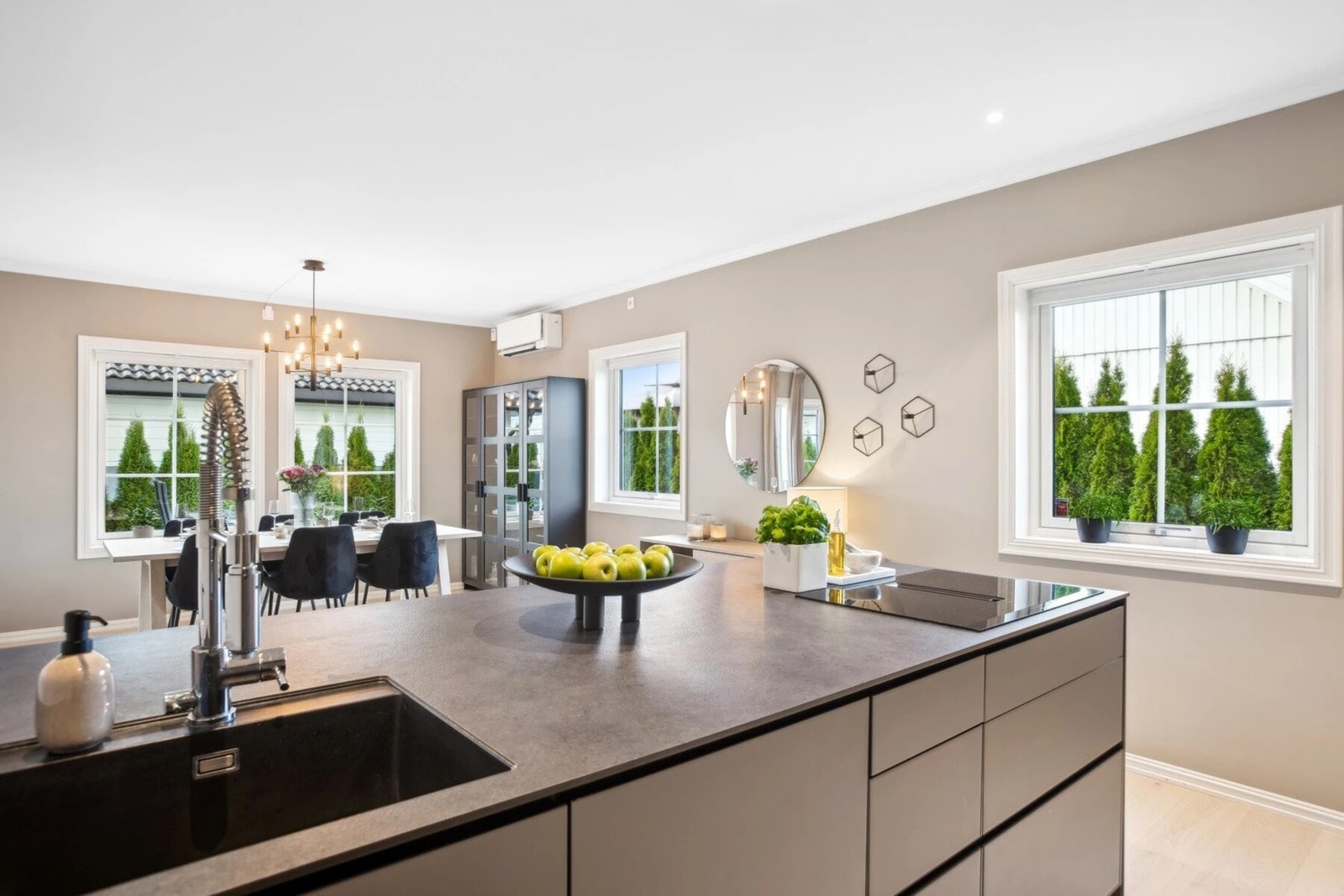 Kjøkkenet er tidløst og elegant, med glatte fronter i en mørkere nyanse som gir en eksklusiv følelse. Galleribilde