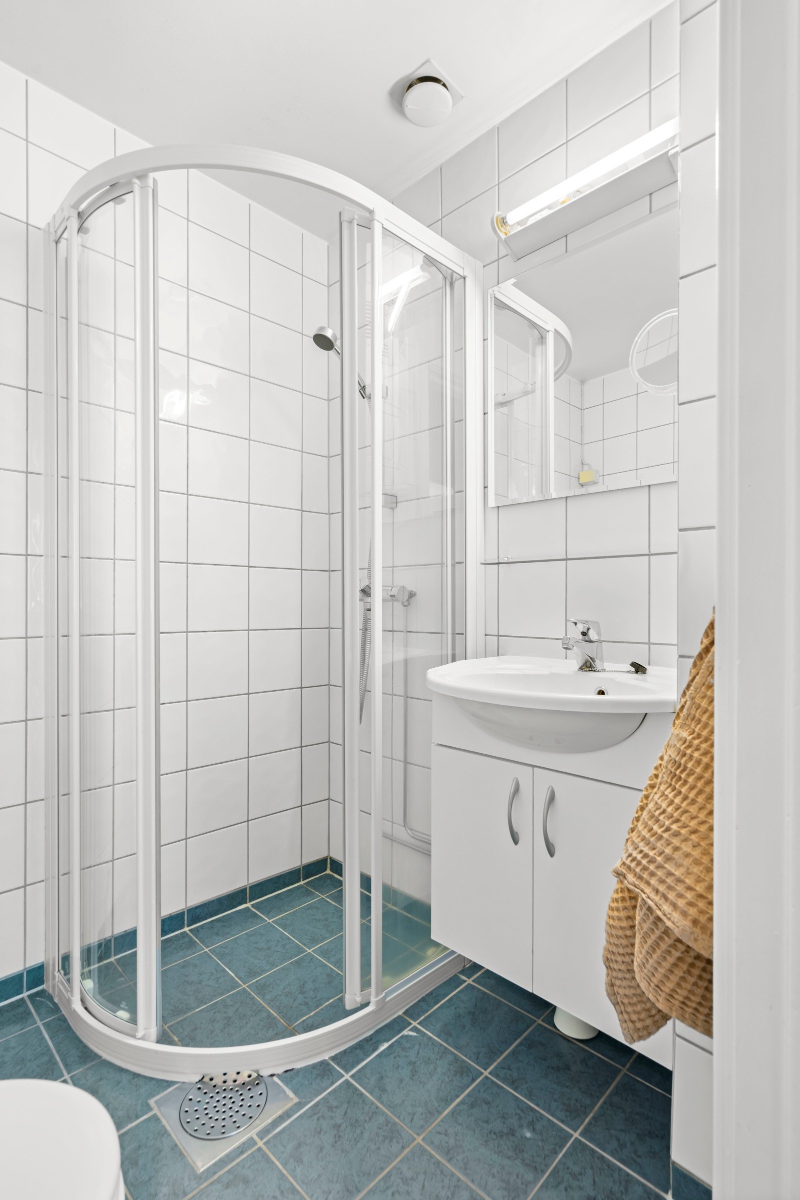 Nøytrale flis- og materialvalg, dusjsone med skyvedører og varmekabler i gulv. Galleribilde