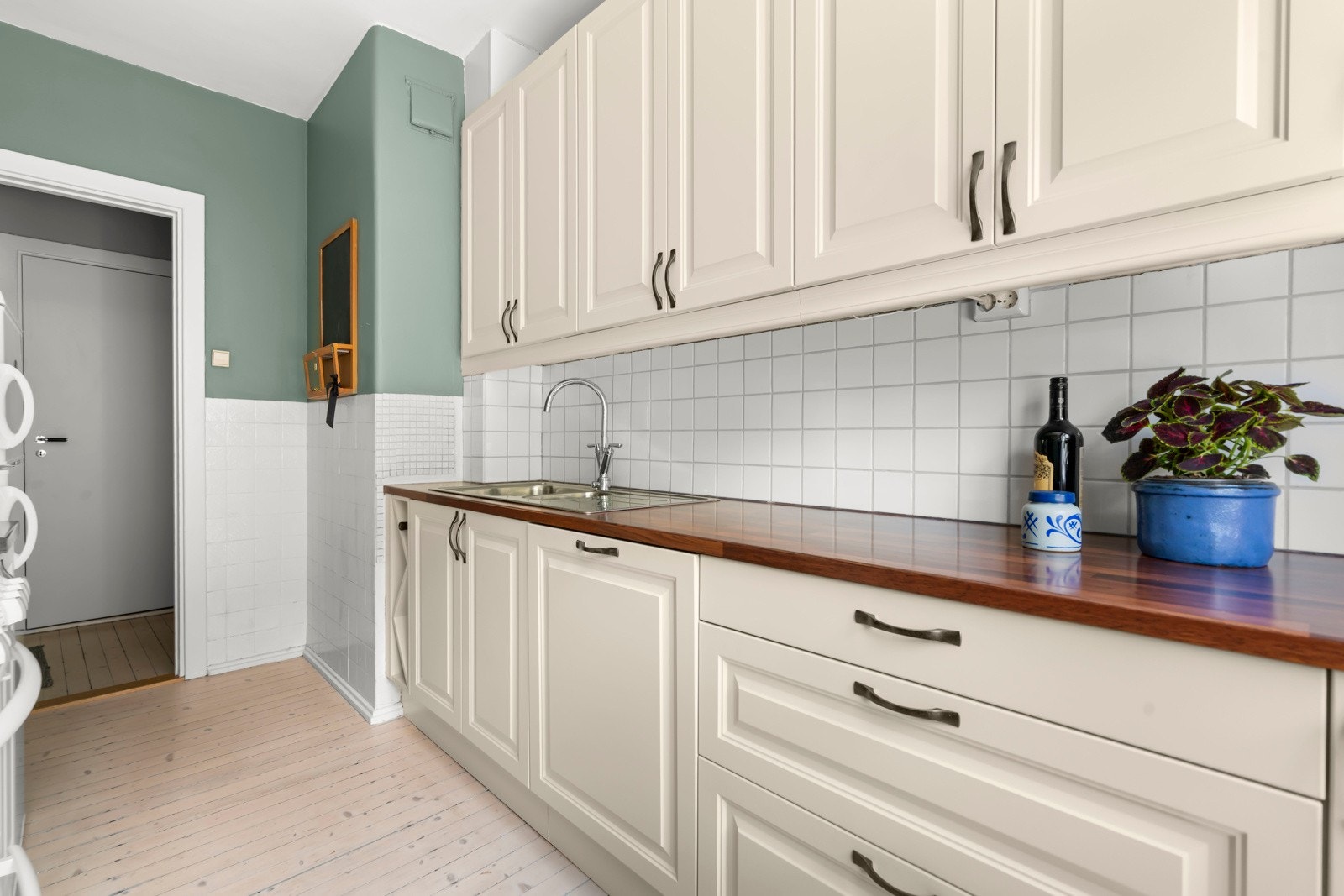 Langstrakt benkeplate i slitesterkt laminat gir gode matlagingsmuligheter. Det er originalt tregulv, malte flater på vegger og malt himling. Galleribilde