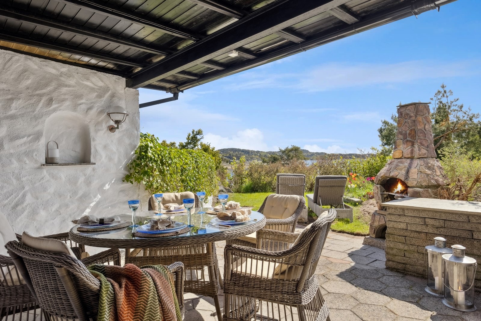 Fra kjøkkenet i underetasjen er det utgang til en hellelagt, dels overbygd uteplass med utepeis og møbleringsfrihet. Galleribilde