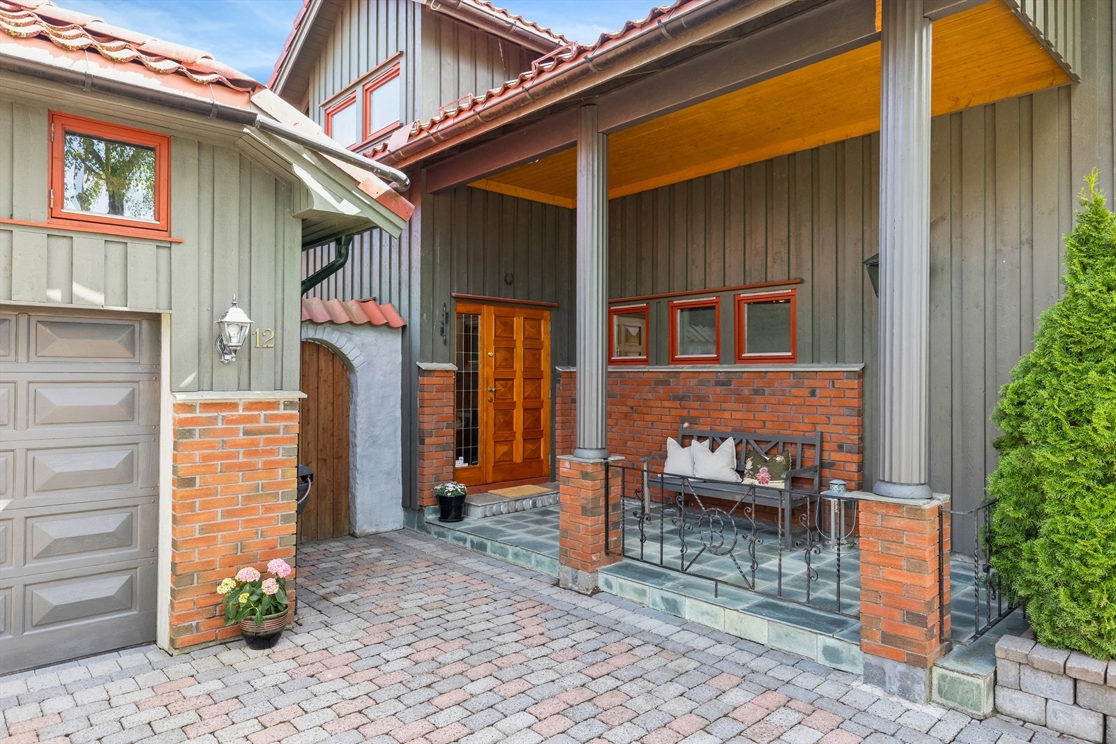 Eneboligen har et stilfullt, overbygd inngangsparti med steinbelagt adkomst, malte søyler og flislagt velkomstterrasse. Galleribilde