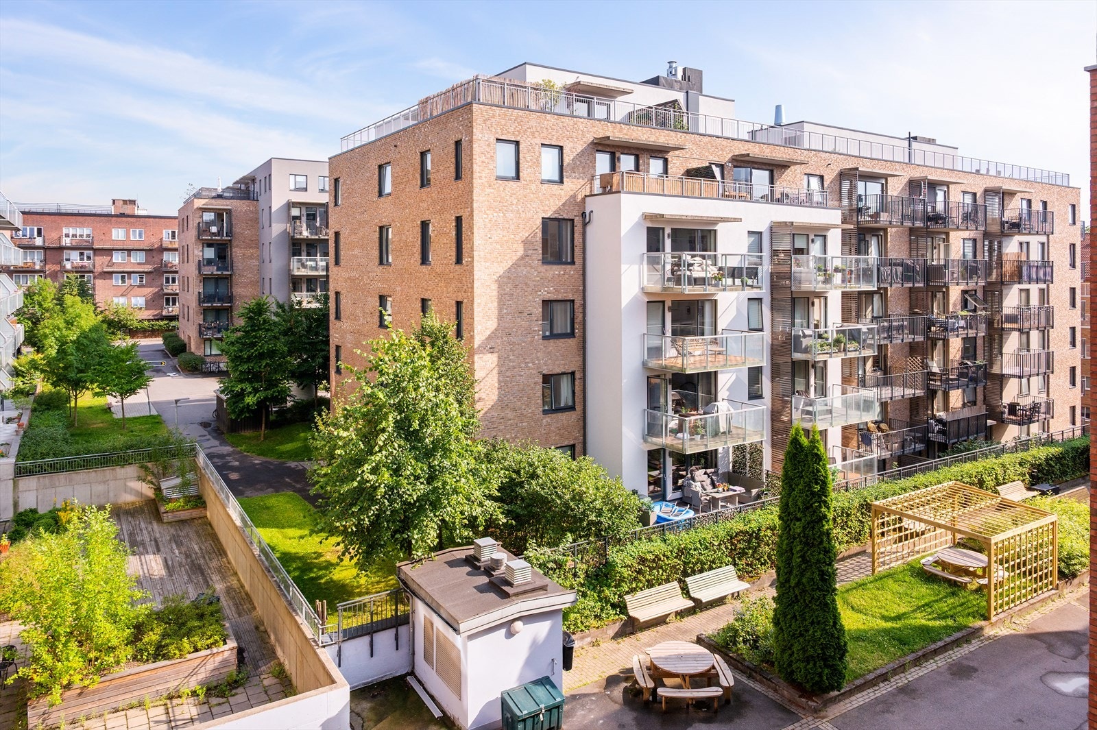 Pent opparbeidet bakgård med sittegrupper, sandkasse for barn m.m. Galleribilde