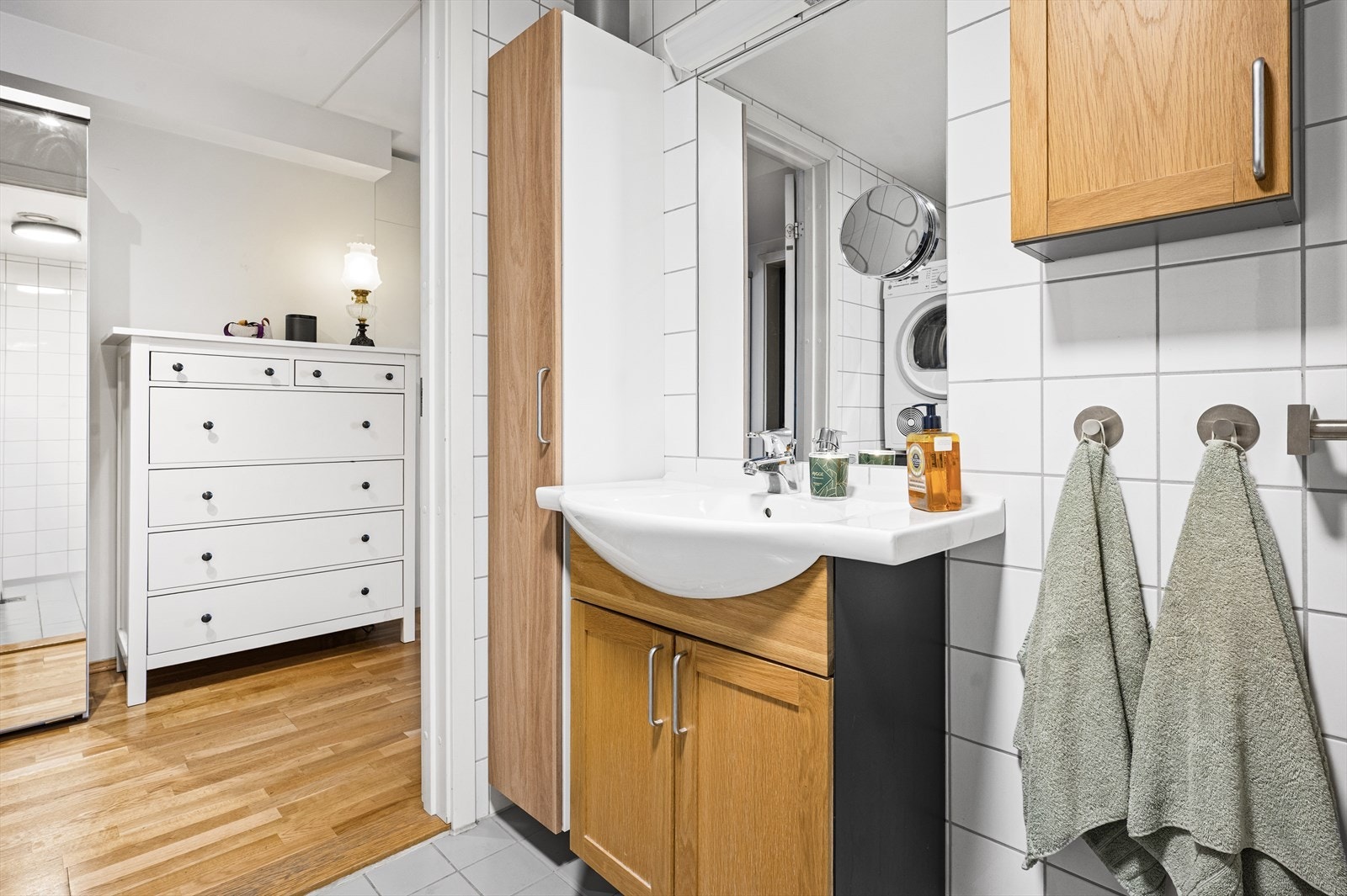 Rommet er innredet med klosett, servant nedfelt i innredning, speil og praktisk dusjhjørne med foldedører. Galleribilde