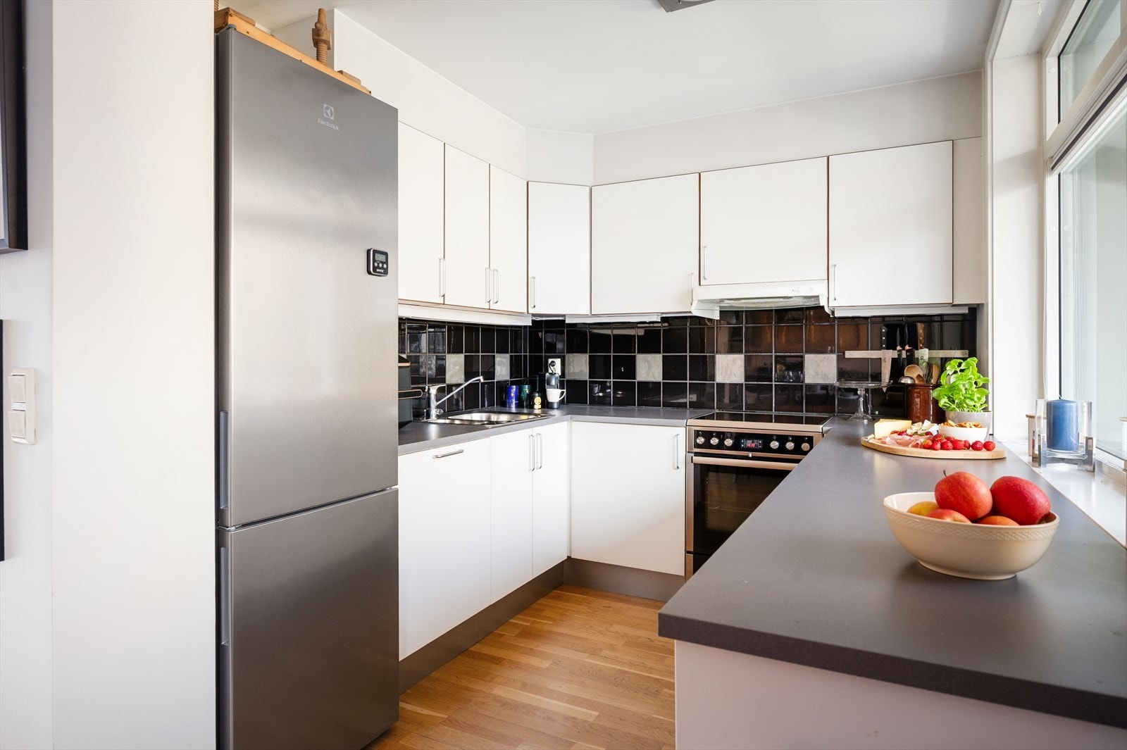 Praktiske fliser og belysning over benkeplaten gir både funksjon og stil. Galleribilde