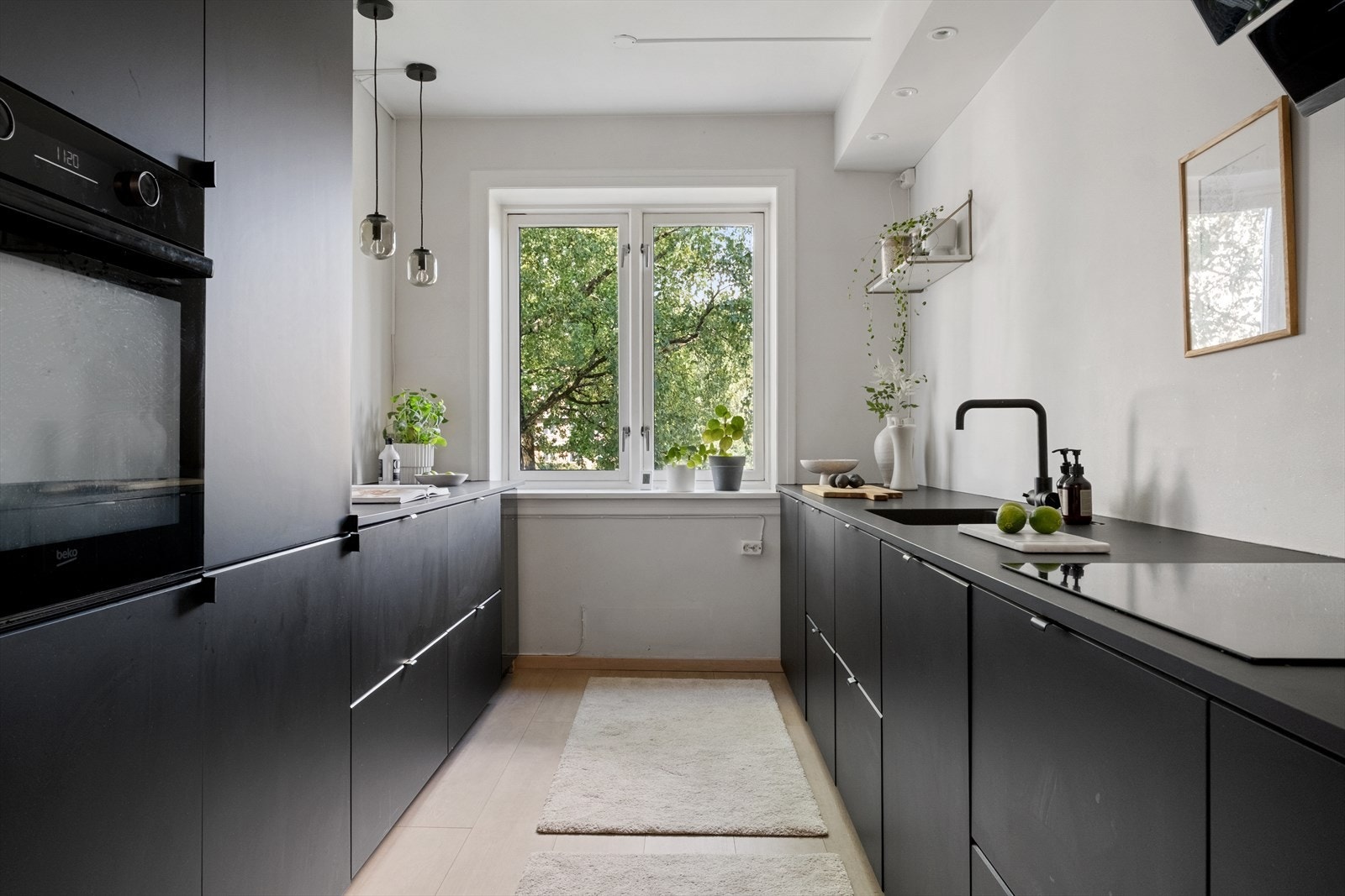 Stilren og tidsriktig kjøkkeninnredning som gjenspeiler leilighetens moderne uttrykk. Galleribilde