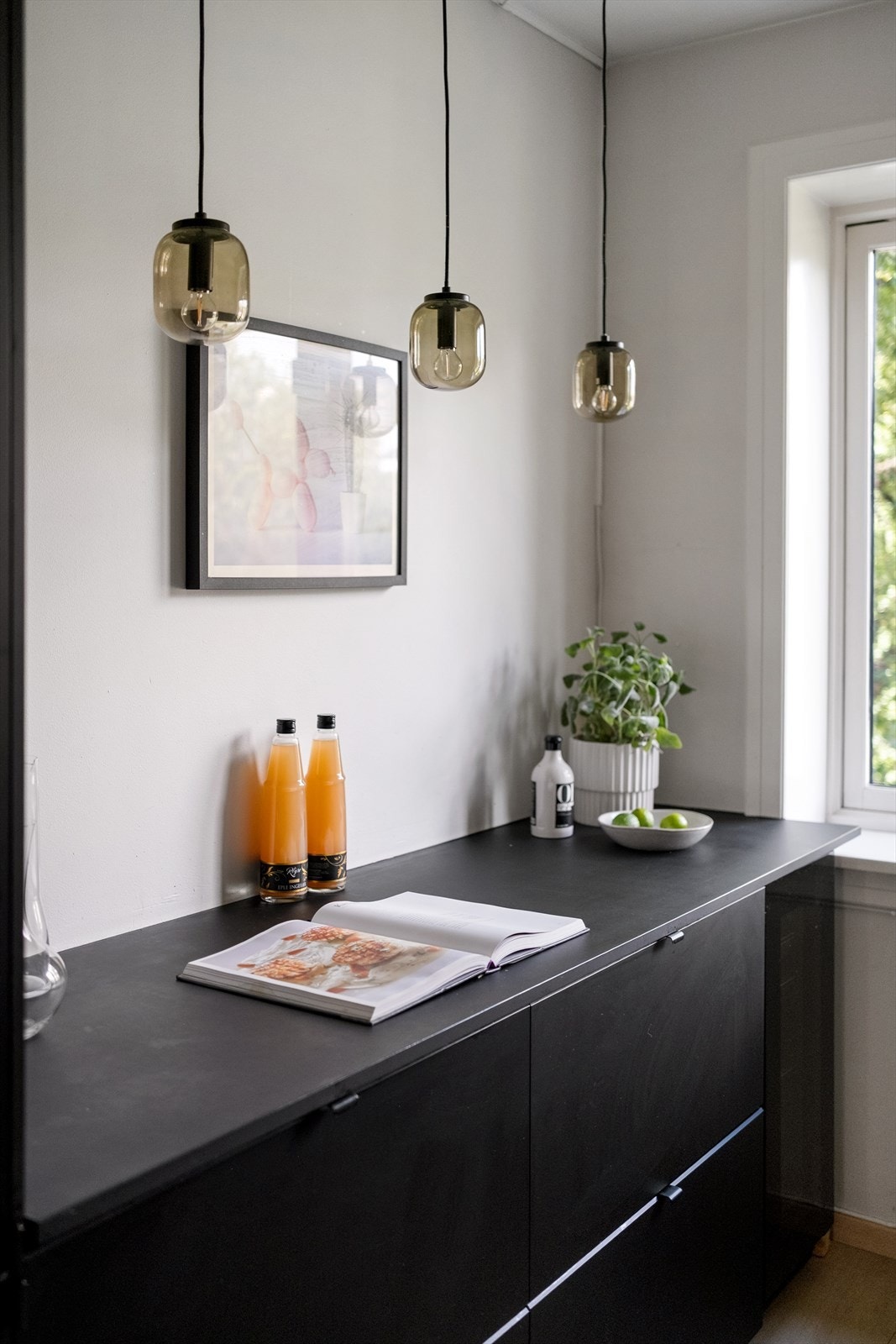 Kjøkkenet har slette fronter i matt sort på innredning. Galleribilde