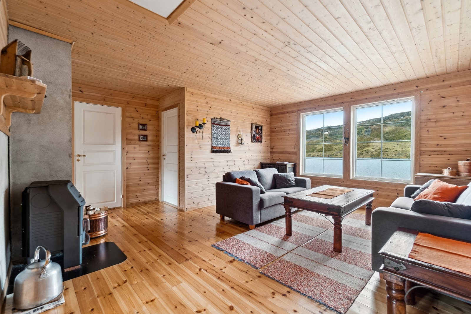 Hytten har en luftig og romslig stue, med flott utsikt mot vannet. Galleribilde