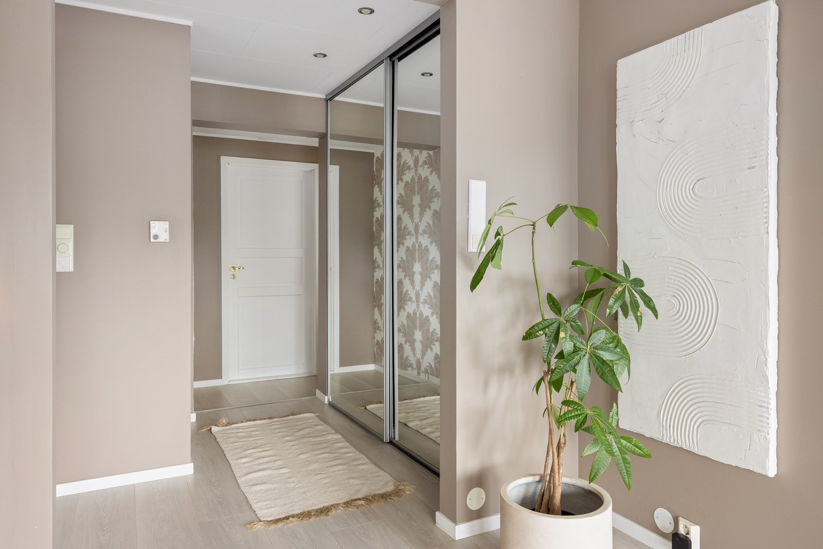 Romslig og innbyende entré med skyvedørsgarederobe. Galleribilde