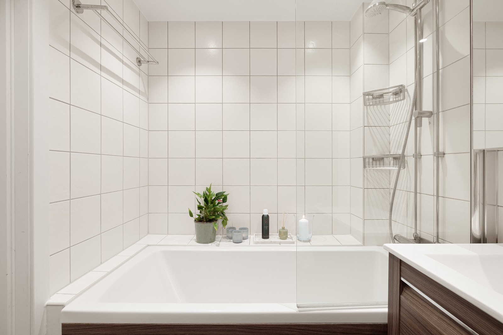 Pent badekar med glassfelt og vegghengt badekar/dusjarmatur. Galleribilde