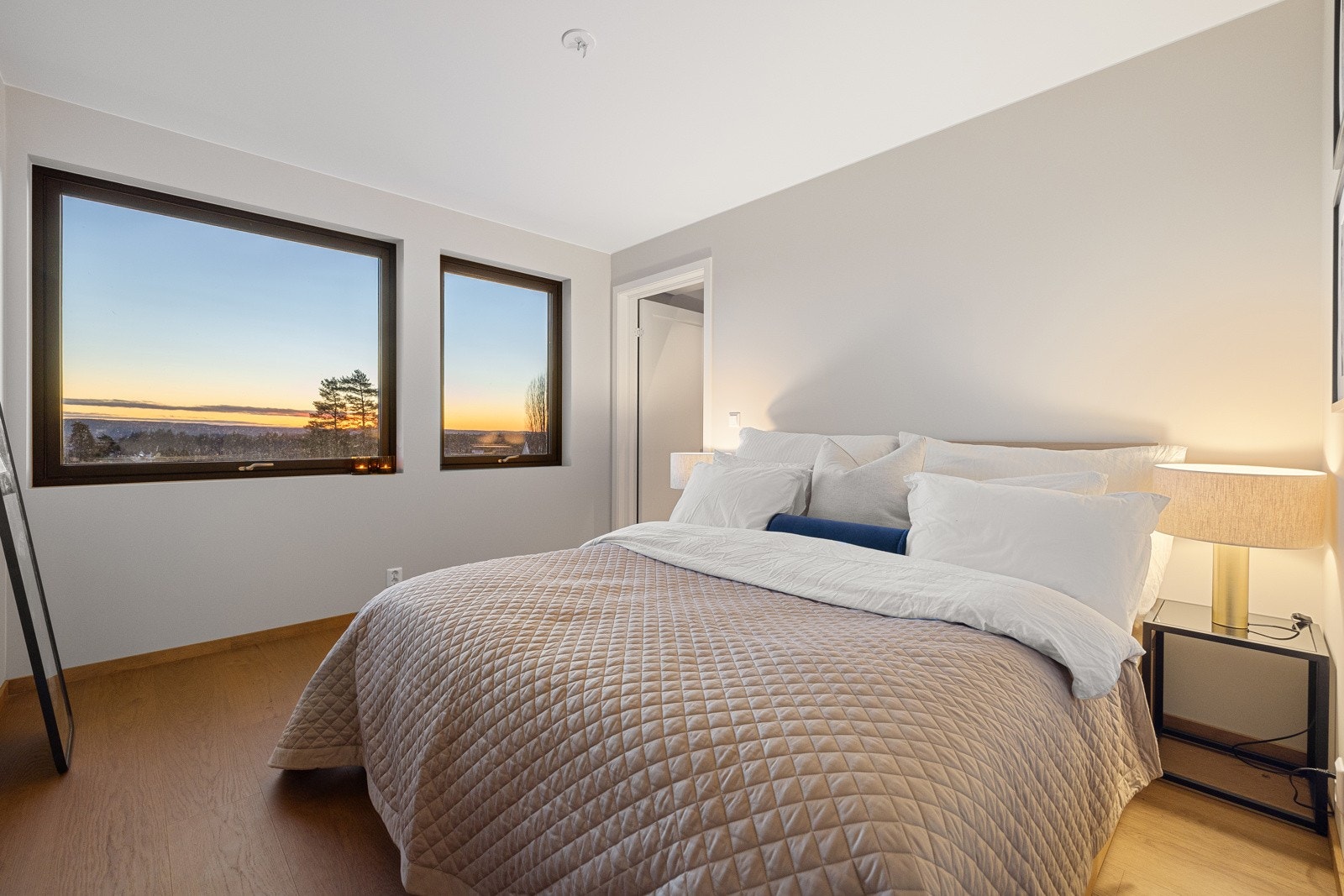 Det har store vinduer som slipper inn naturlig lys og gir flott utsikt mot grønne omgivelser, samt romslig med god plass til dobbeltseng og nattbord Galleribilde