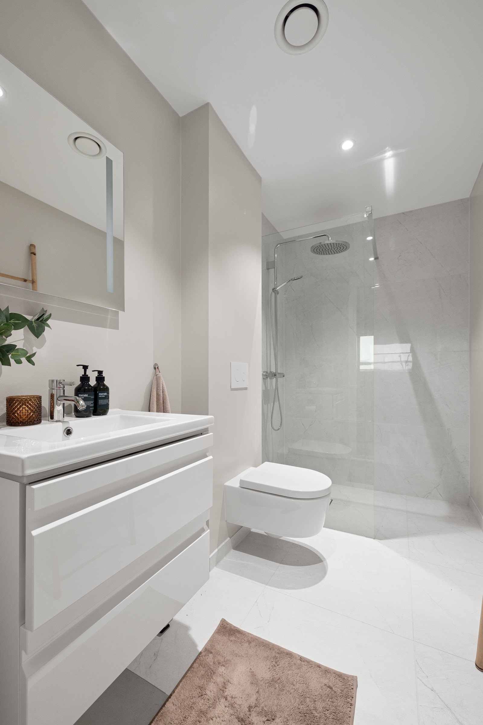 Badet har vegghengt toalett med innebygd sisterne og dusjnisje. Galleribilde