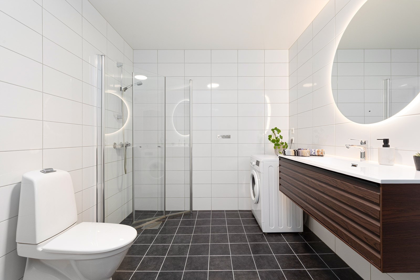 Heilflisa kombinert bad/vaskerom som inneheld toalett, dusjveggar, opplegg for vaskemaskin... Galleribilde
