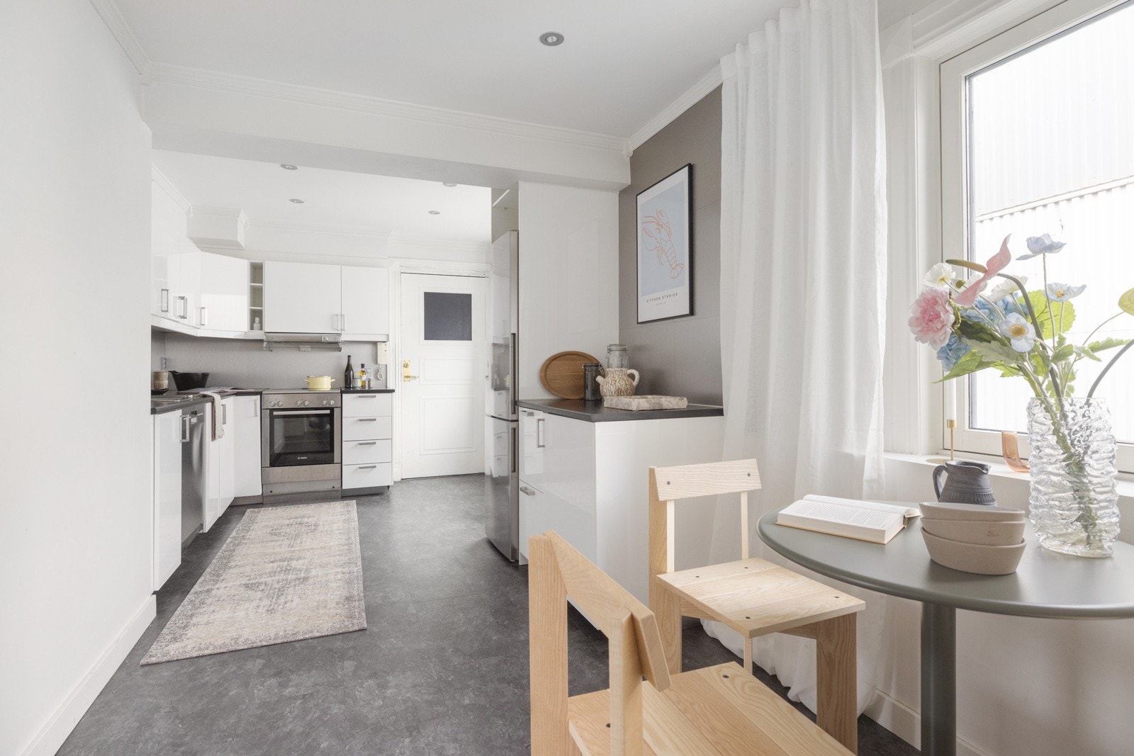 Leiligheten har et romslig IKEA-kjøkken fra 2016 med slette hvite og høyglanslaminerte fronter. Galleribilde