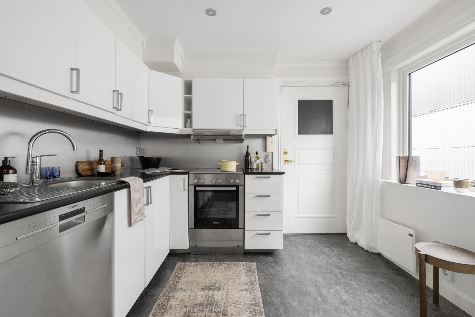 Mørk laminat benkeplate med nedfelt vaskekum i børstet stål, og ettgreps blandebatteri i rustfritt stål fra Grohe. Galleribilde